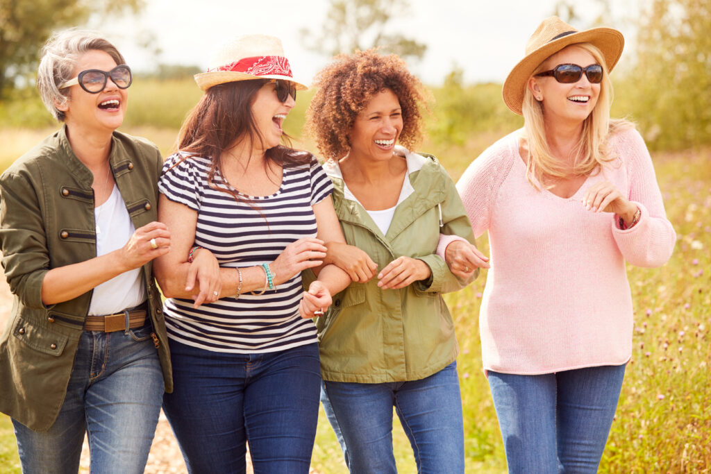 Group,Of,Mature,Female,Friends,Walking,Along,Path,Through,Yurt